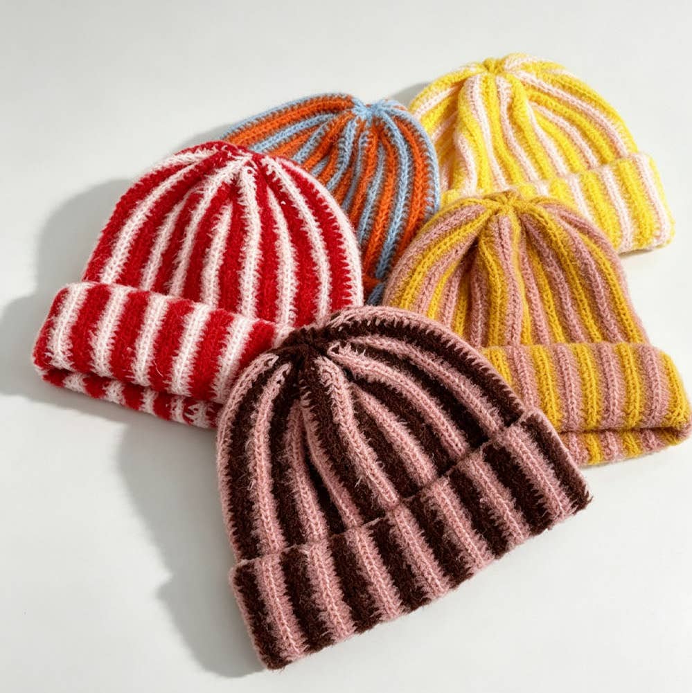Four striped ribbed knit beanies in red/white, orange/blue, yellow/pink, and brown/pink colorways with cuffed brims.