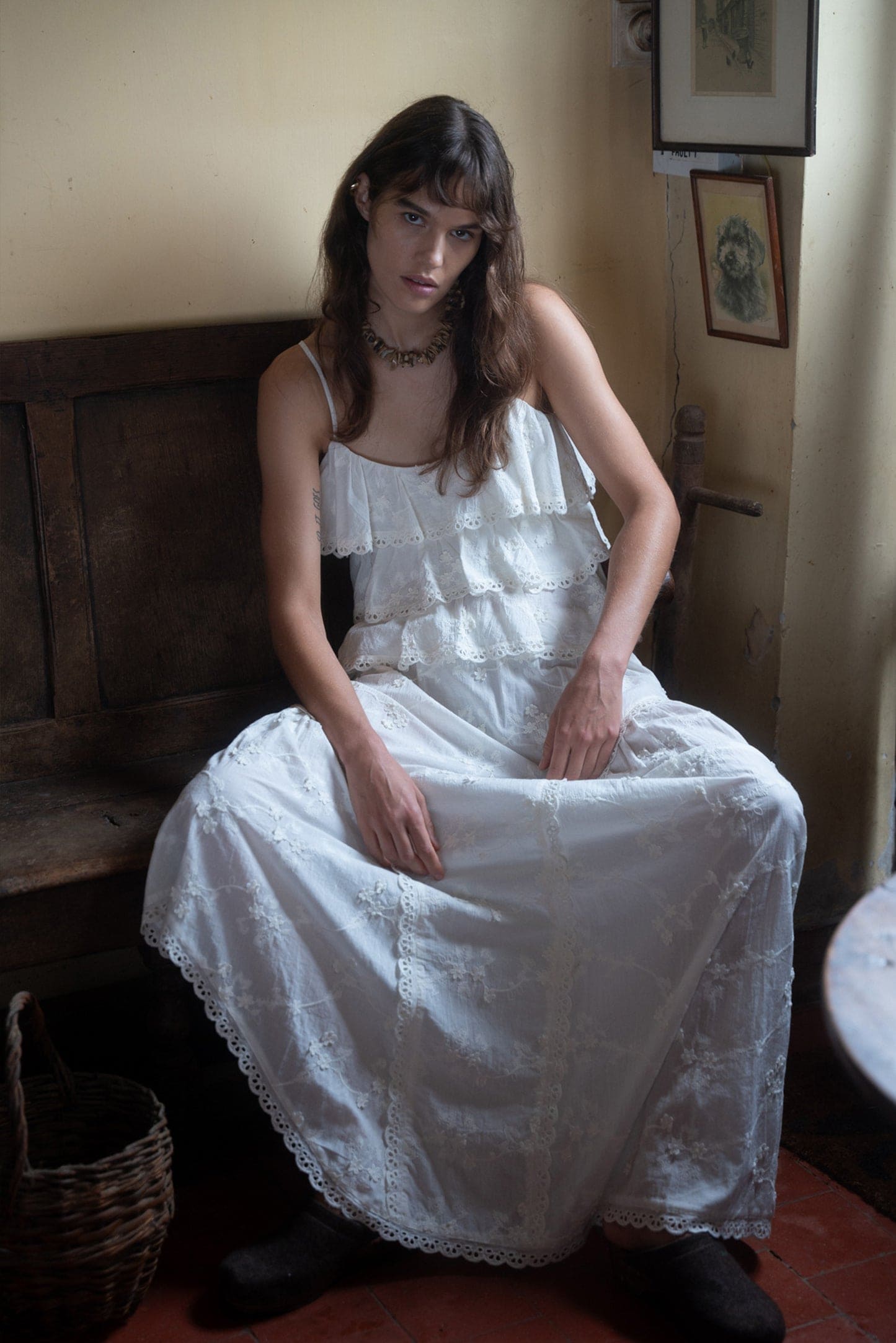 White tiered eyelet lace maxi dress with spaghetti straps and ruffled bodice in embroidered cotton fabric