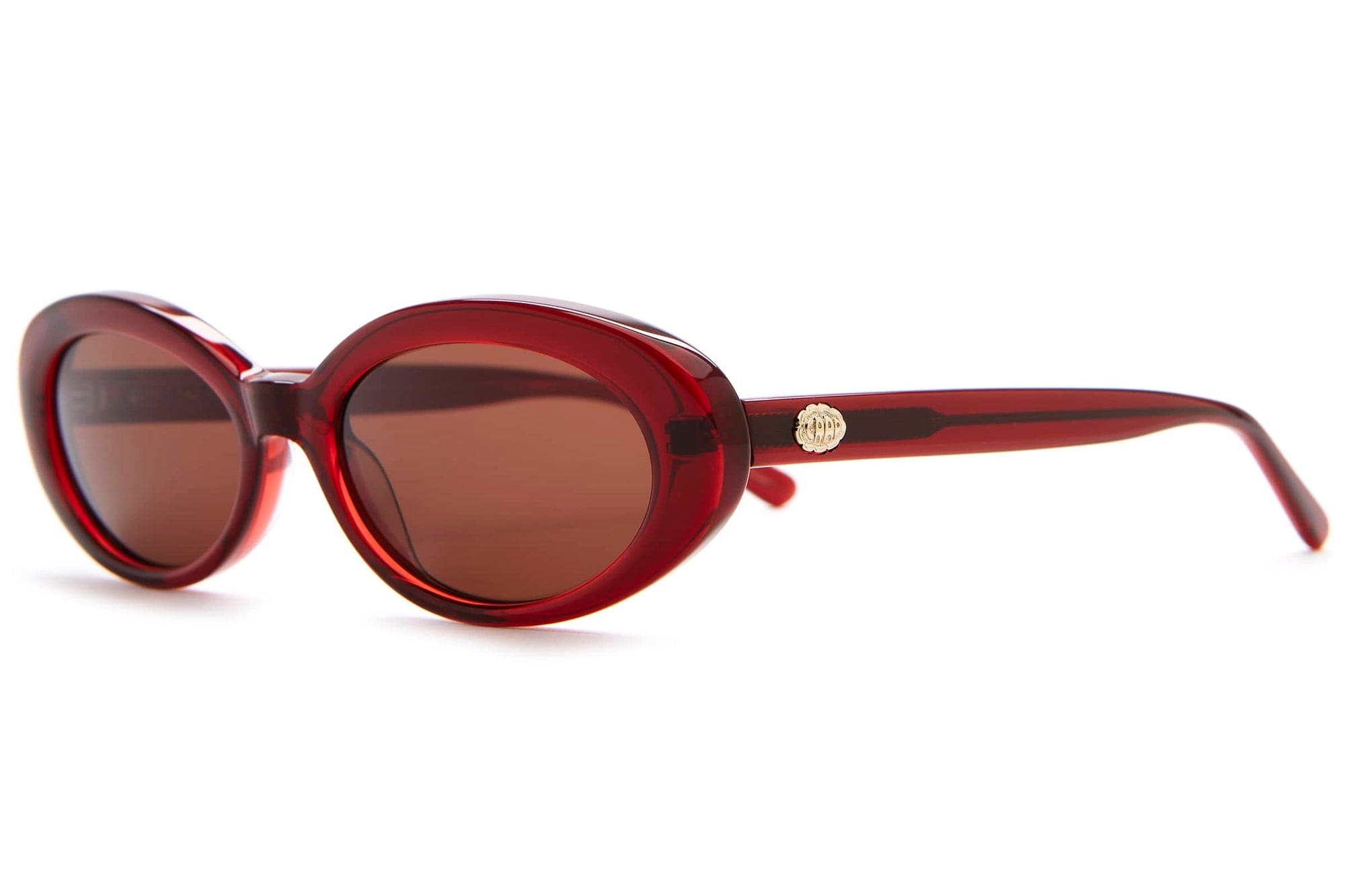 Red translucent oval sunglasses with brown tinted lenses and gold medallion accent on temple arms