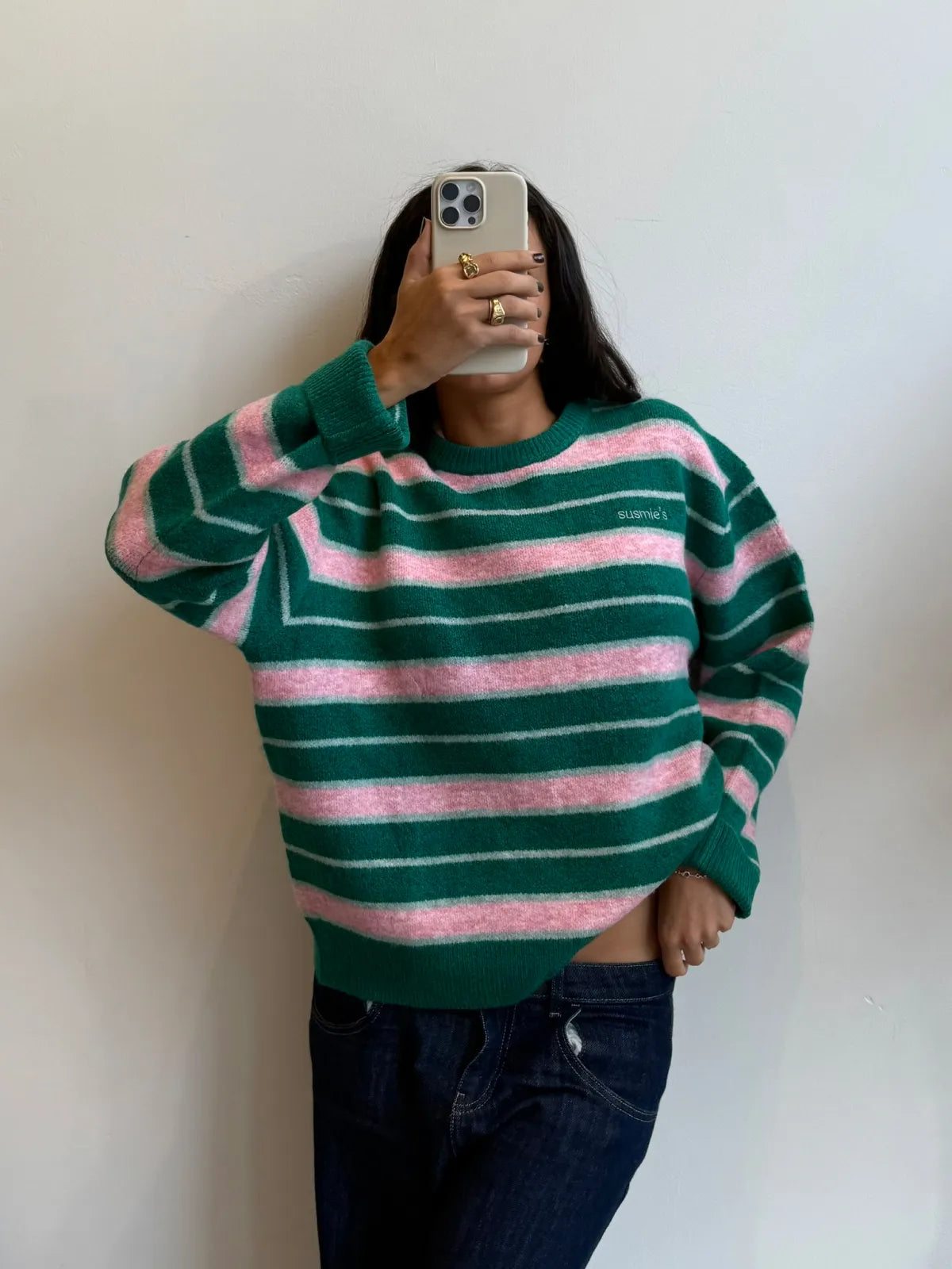 Green and pink striped knit sweater with relaxed fit and crew neck, styled with dark jeans