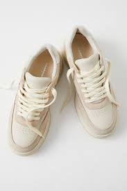 Cream canvas high-top sneakers with white laces and rubber soles, casual unisex athletic shoes