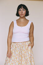 Light pink sleeveless tank top with scoop neckline, made of stretchy ribbed fabric with gathered waist detail