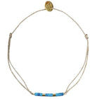 Adjustable beige cord bracelet with blue and gold beads and gold coin charm at top