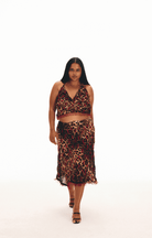 Leopard print two-piece set with halter crop top and midi skirt featuring fringe trim details in red, black and tan