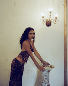 Woman wearing leopard print two-piece set with fringe detail crop top and matching skirt in brown and black tones