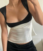 Person wearing a black and white top with a plain background