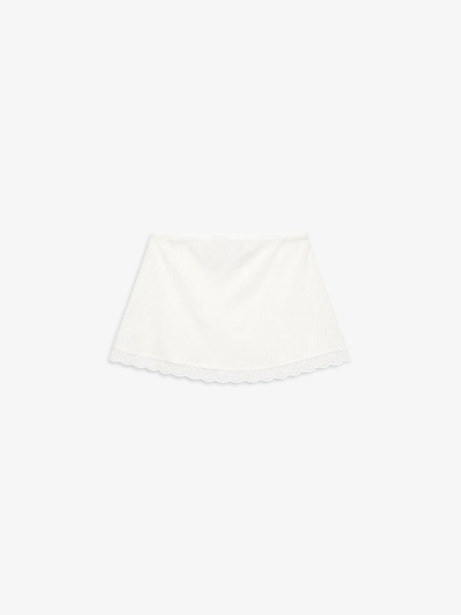 White lace-trimmed linen skirt with elastic waistband laid flat on light background
