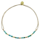 Delicate beaded bracelet with turquoise stones and gold accents on adjustable taupe cord with gold slider clasp
