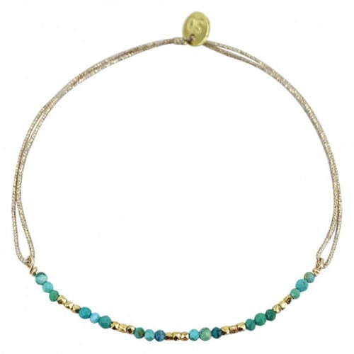 Delicate beaded bracelet with turquoise stones and gold accents on adjustable taupe cord with gold slider clasp