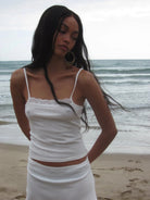 White ribbed knit crop top and skirt set with lace trim detail and thin straps, beachside photo