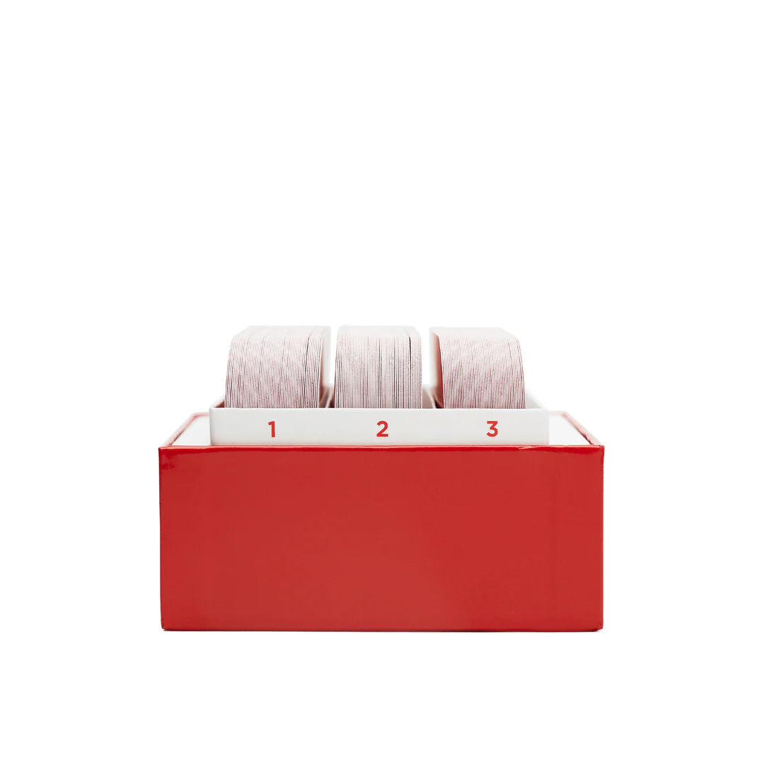 Red leather card file box with three numbered sections holding organized playing cards with striped backs
