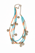 Multistrand beaded necklace with coin pendants on a white background