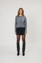 Grey button-front crew neck cardigan, fine knit, long sleeves, cropped fit, worn with black shorts and lace tights.