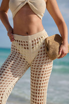 Person wearing a beige crochet outfit on a beach