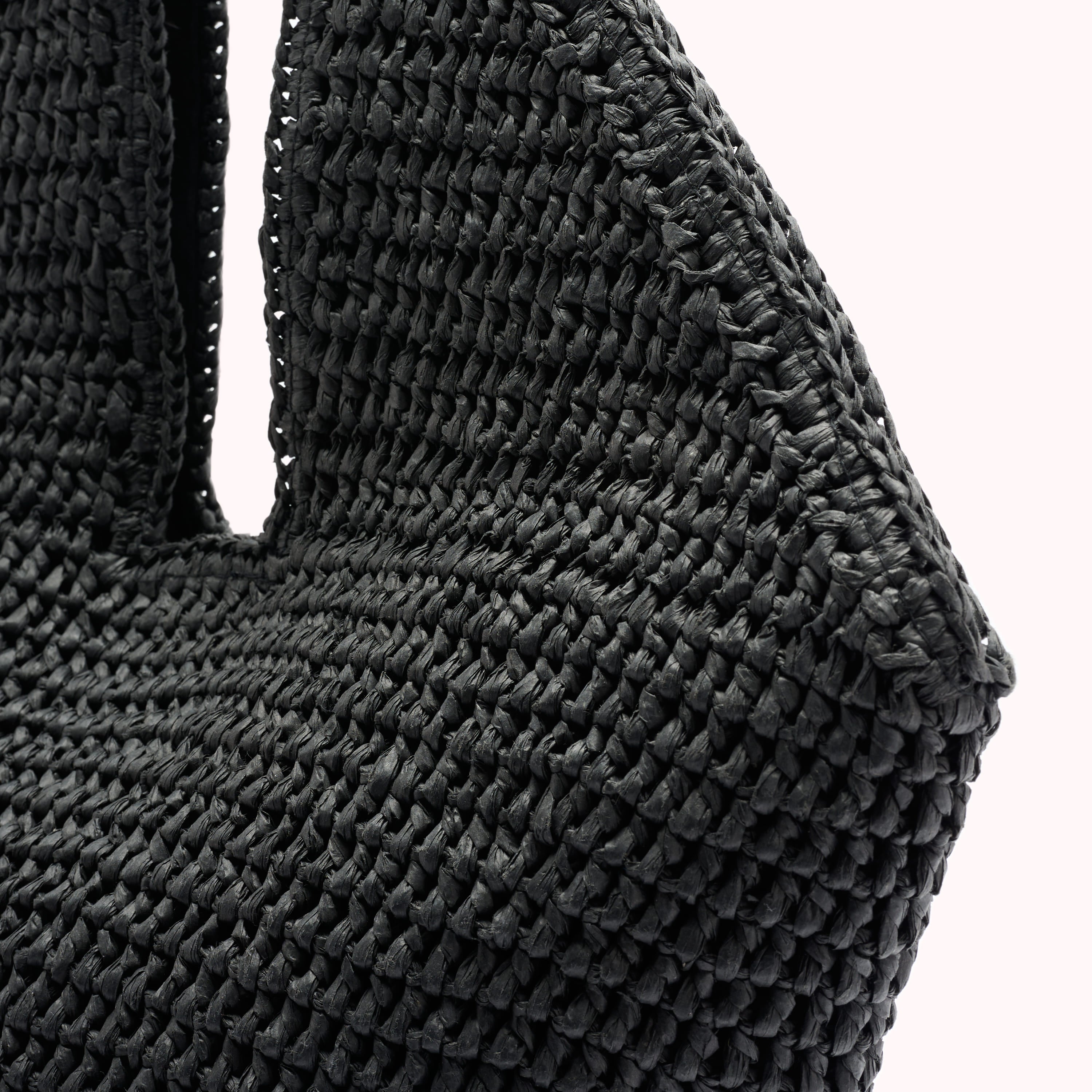 Close-up of a black woven bag with a white background