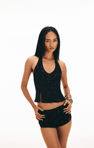 Black sequined halter top and mini skirt set with cutout detail and form-fitting silhouette