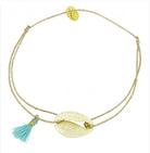 Gold adjustable bracelet with cream cowrie shell centerpiece and turquoise tassel charm on delicate chain