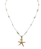 Gold starfish pendant necklace with green and white beaded chain on delicate cord