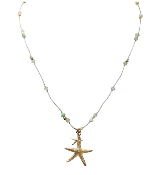 Gold starfish pendant necklace with green and white beaded chain on delicate cord
