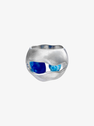 Silver sculptural ring with wavy cutout design featuring blue opal stones visible through organic openings