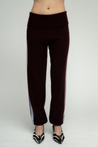 Dark burgundy knit wide-leg pants with light blue side stripes and fold-over waistband, styled with zebra print heels.