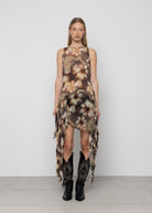 Sleeveless tie-dye dress in brown and cream tones with asymmetric ruffled hem, worn with black embroidered cowboy boots