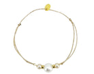 Adjustable beige cord bracelet with three white pearls and gold beads, featuring gold slider clasp
