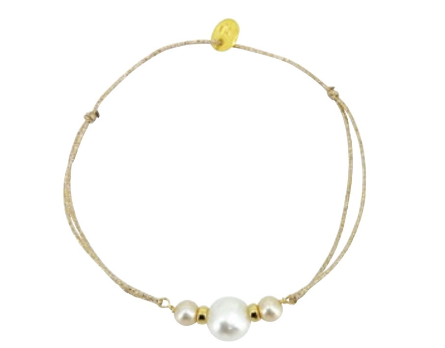 Adjustable beige cord bracelet with three white pearls and gold beads, featuring gold slider clasp
