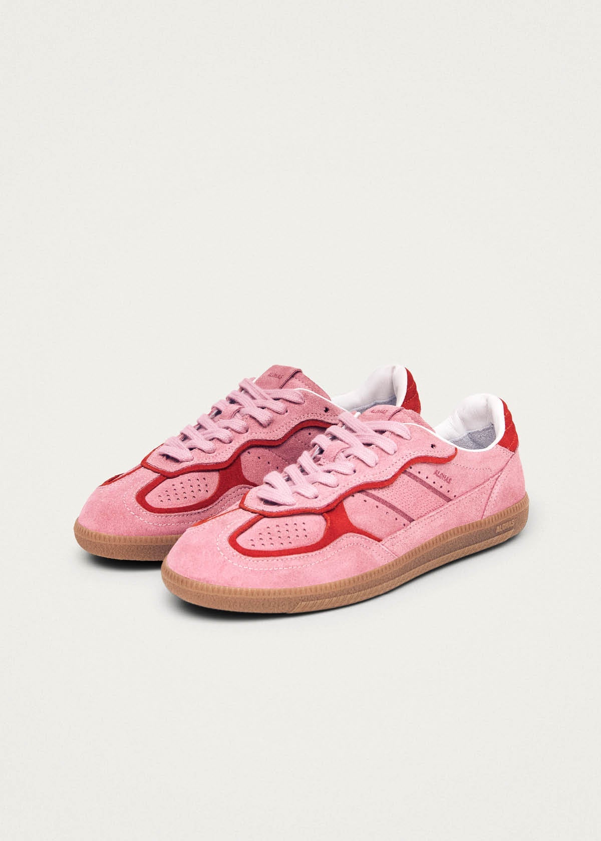 Pink suede sneakers with red accent trim, gum sole, and white heel tab in classic low-top silhouette