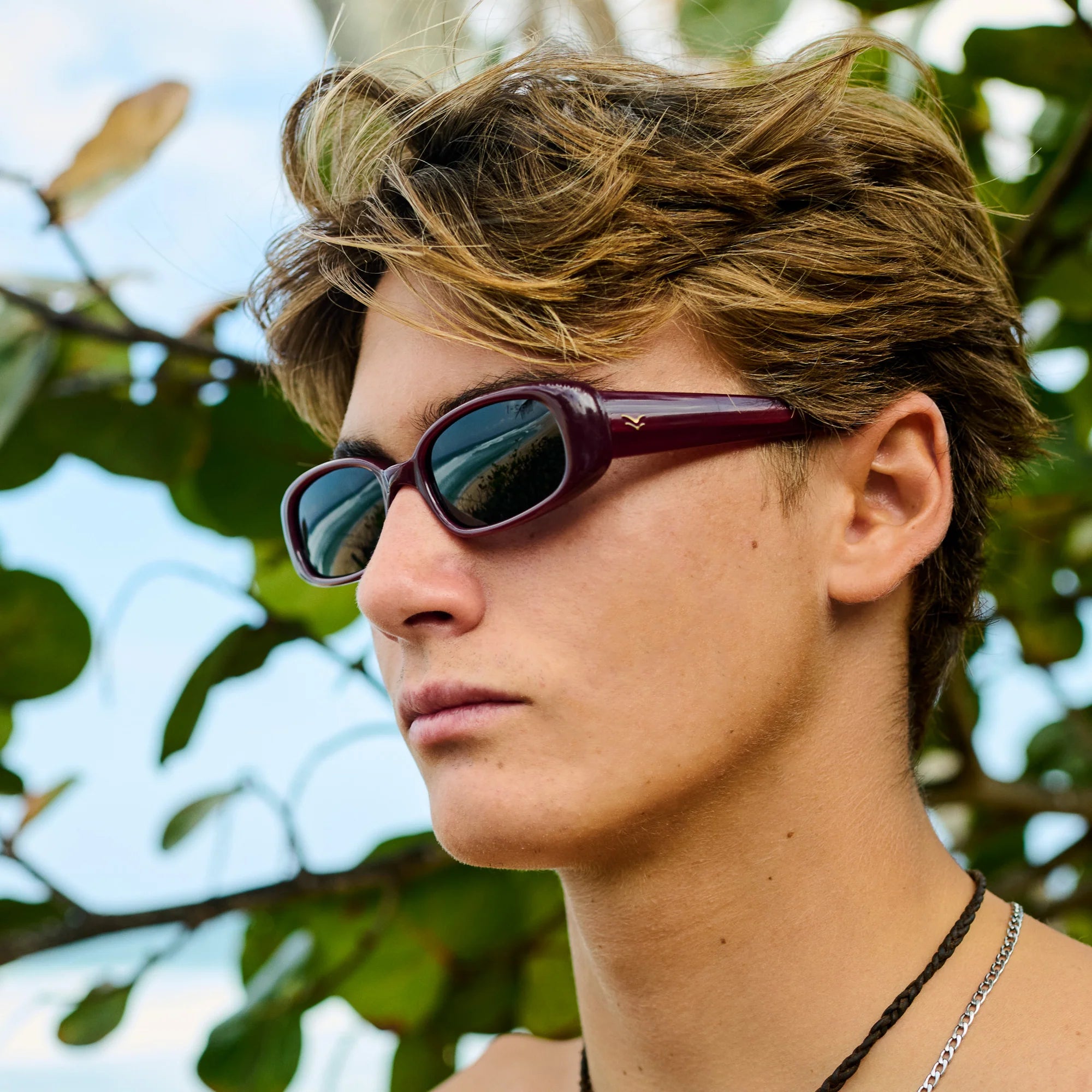 Person wearing sunglasses with a blurred natural background
