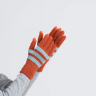 Orange and light blue striped knit gloves with ribbed texture and extended cuffs displayed on raised hand