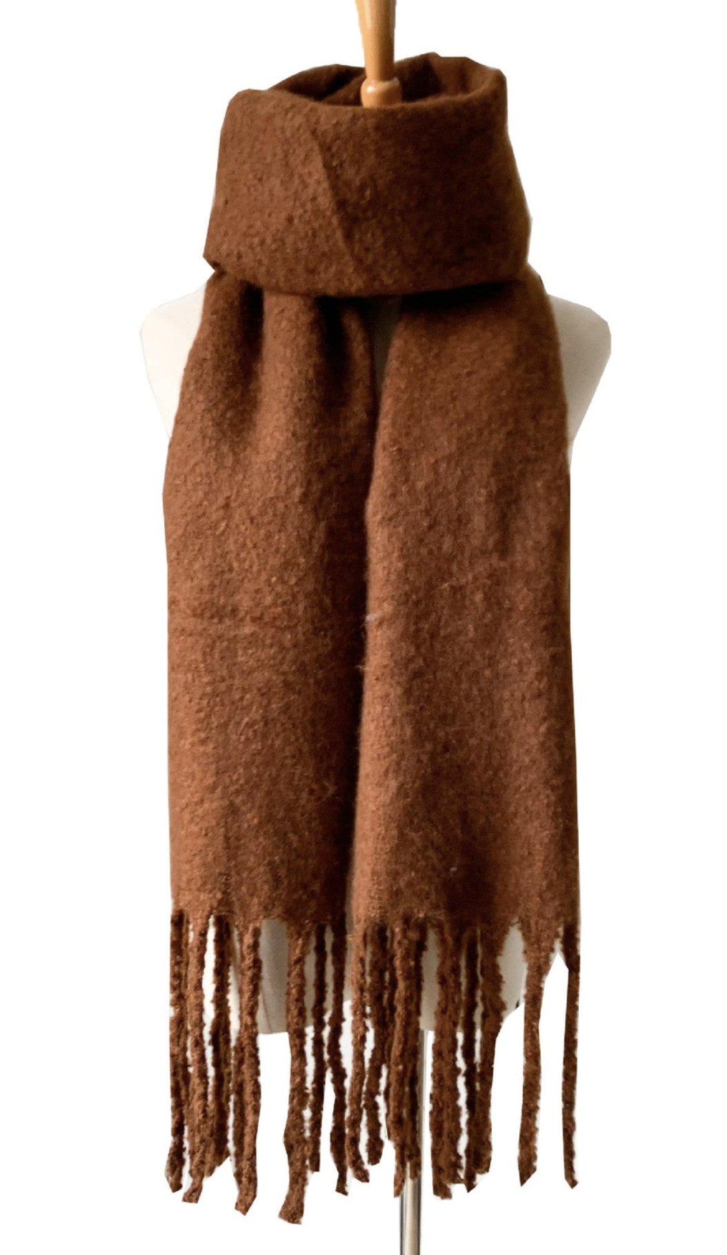 Brown textured knit scarf with fringe tassels displayed on white mannequin bust against white background