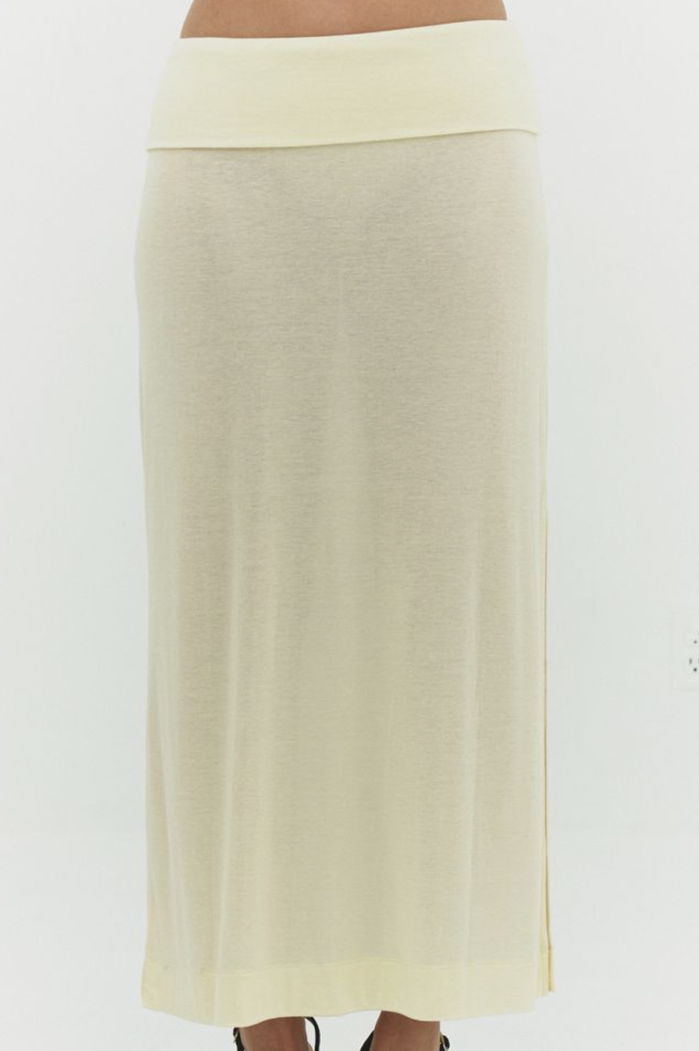 Cream colored maxi skirt with wide fold-over waistband in heathered knit fabric, worn with sandals