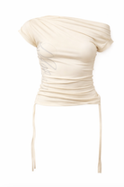 Cream colored ruched off-shoulder top with draped sleeves and side tie detail in luxe satin fabric
