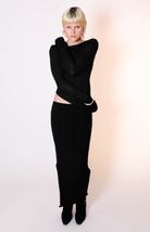Black long-sleeve cropped top and matching maxi skirt set in ribbed knit fabric with exposed midriff