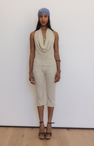 Beige textured knit halter top and capri pants set with cowl neckline, worn with blue beanie and platform sandals