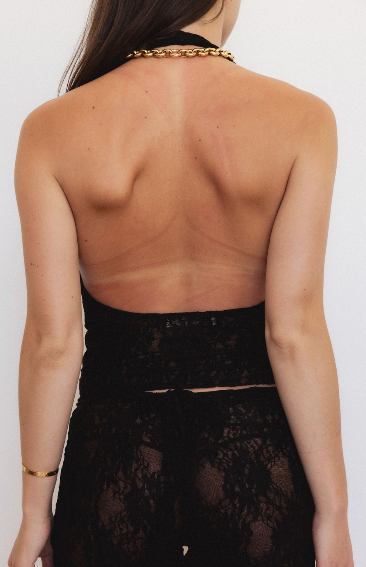 Black lace halter top with chain neck detail and open back design