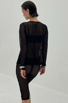 Black sheer striped knit top and skirt set with semi-transparent fabric showing layered undergarments beneath