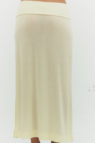 Cream-colored maxi skirt with fold-over waistband in soft knit fabric, shown on model from waist down