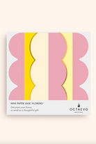Flat-packed mini paper vase with colorful wavy stripes in pink, yellow, and cream, labeled Florero by Octaevo Barcelona