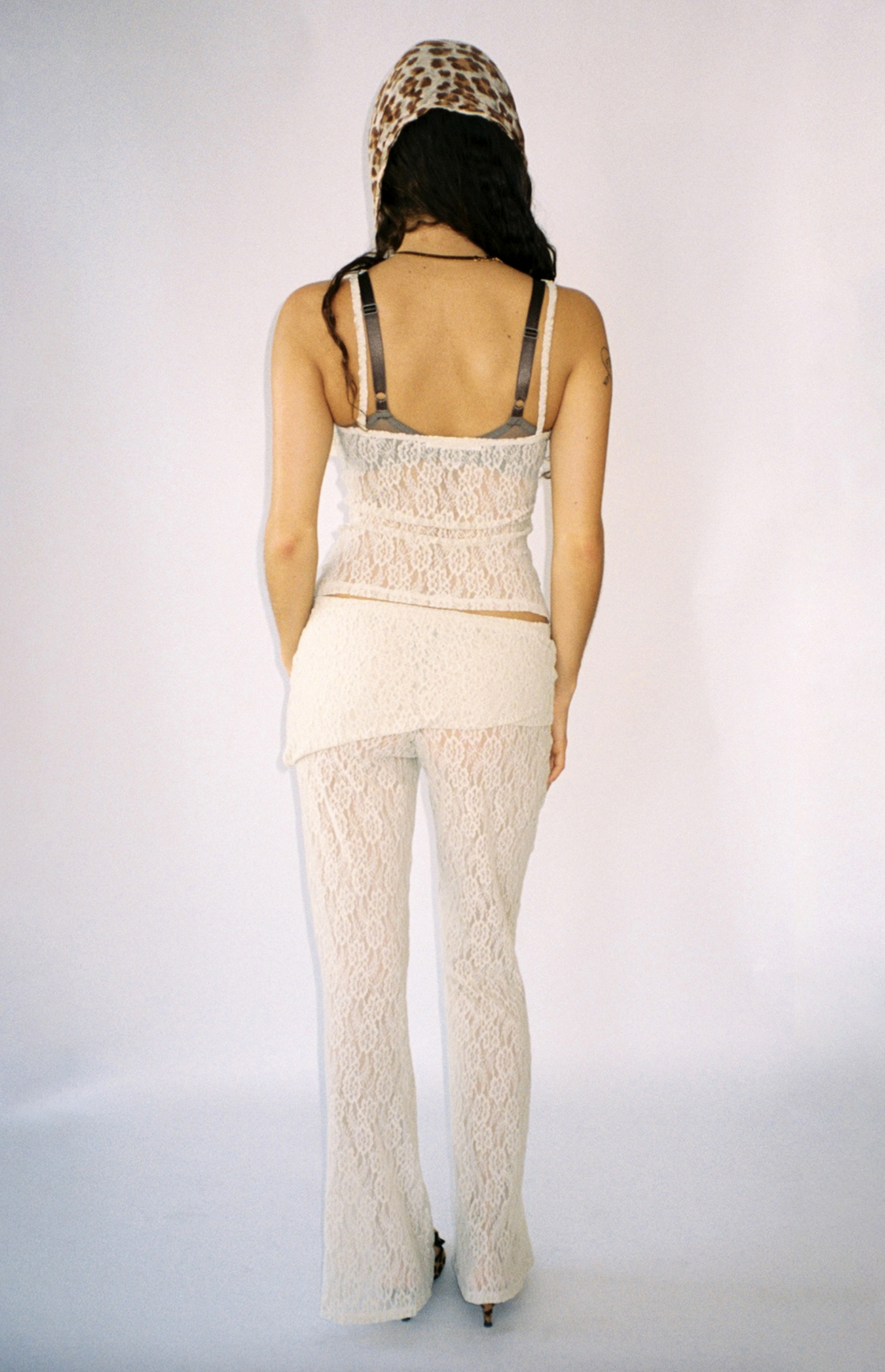 White lace cami top and pants set with visible bra straps and leopard print headscarf, shown from back