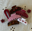 Assorted hair clips and claw clips in red, burgundy, brown tortoiseshell with gingham, polka dot patterns and cherry embellishments
