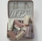 Travel case with hair styling tools including combs, clips, and accessories in pastel pink, cream, and lavender colors