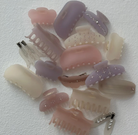 Collection of hair clips and claws in pastel pink, purple, and clear colors with rhinestone embellishments on white background