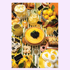 Lemon-themed dessert table with yellow tart, cakes, cookies, lemonade pitchers, and fresh lemons on striped tablecloth