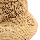Beige woven bucket hat with shell design on a white background
