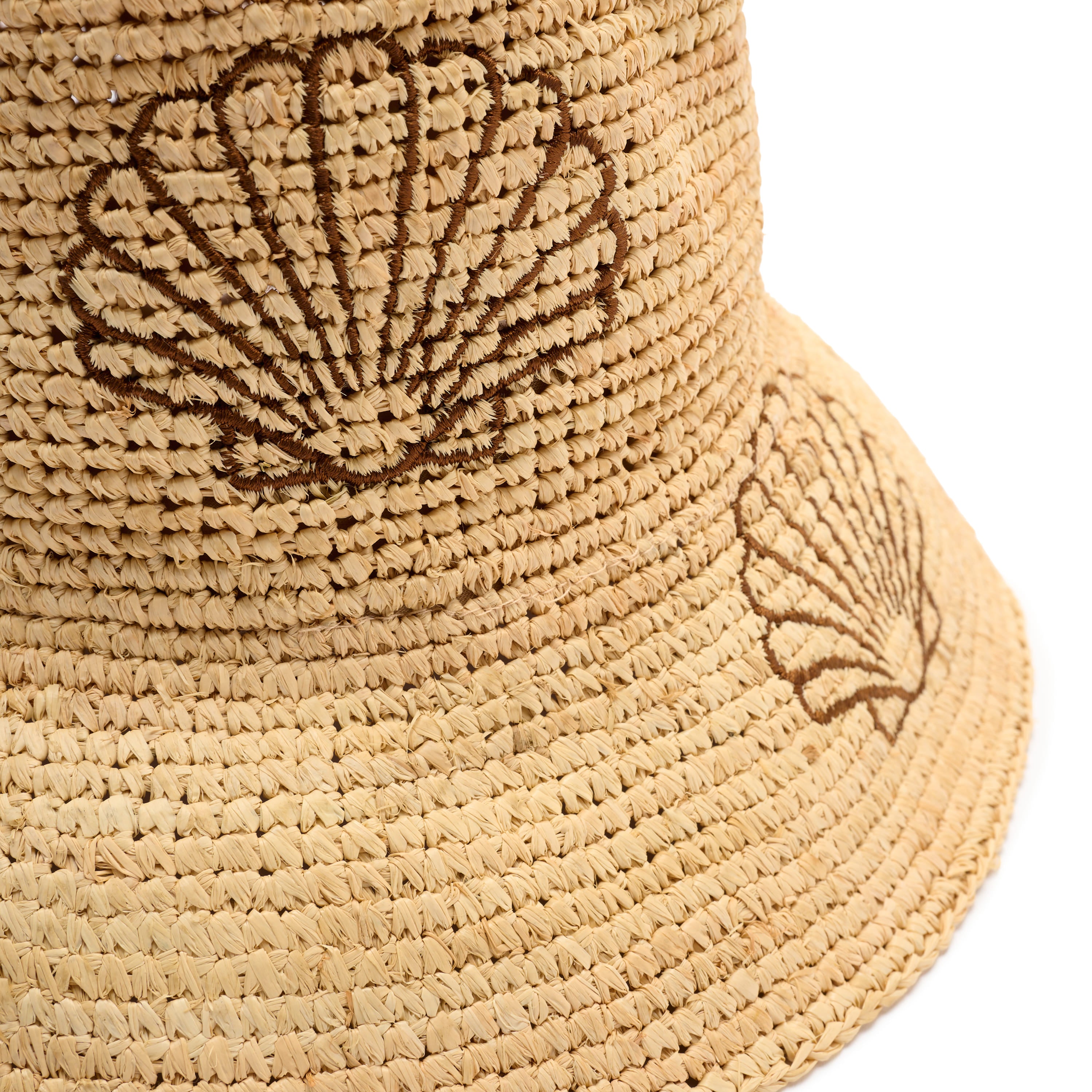 Beige woven bucket hat with shell design on a white background