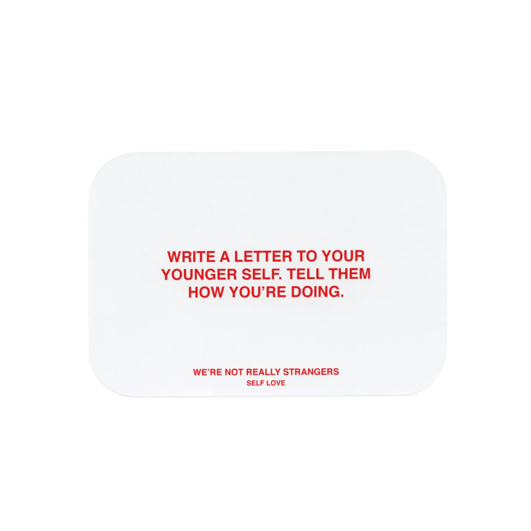 White rounded square card with red text reading "Write a letter to your younger self. Tell them how you're doing." Self love theme