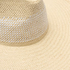 Close-up of a woven straw hat on a matching beige background