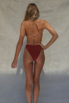 Person wearing a red bikini against a neutral background
